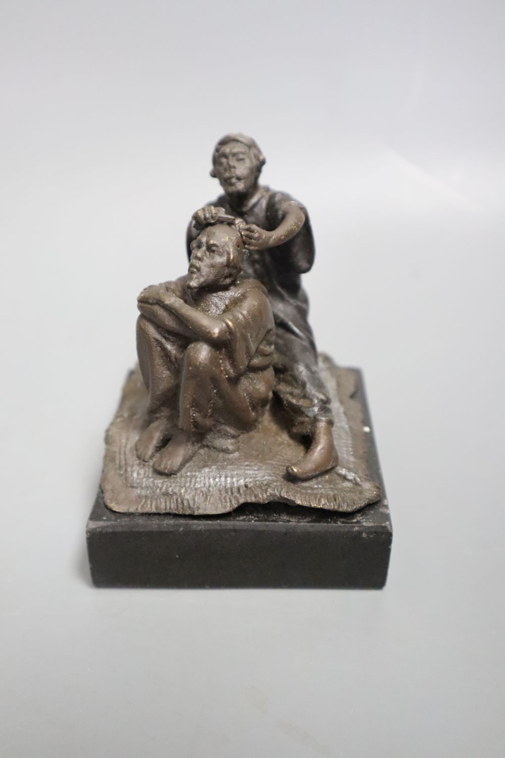 A cast metal sculpture Kiss after Rodin, height 14cm and another of Arabs